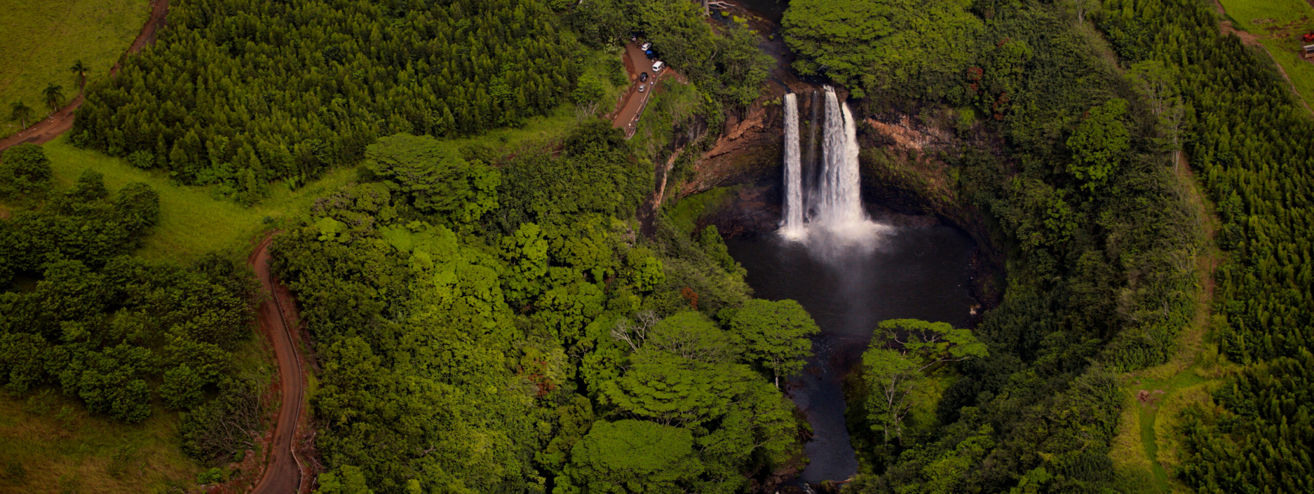 Drone image of waterfalls in a forest.